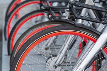 A close up of a bicycle wheel with a red rim and silver spokes.